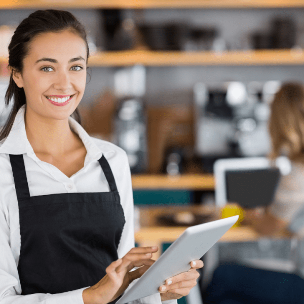 Portrait of smiling waitress using digital tablet in cafe